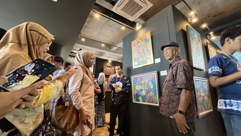 Dua pengunjung mengamati karya seni anak autis yang dipamerkan di GIK UGM dalam acara “I’M POSSIBLE – Ekspresikan Dirimu” tahun 2025.
