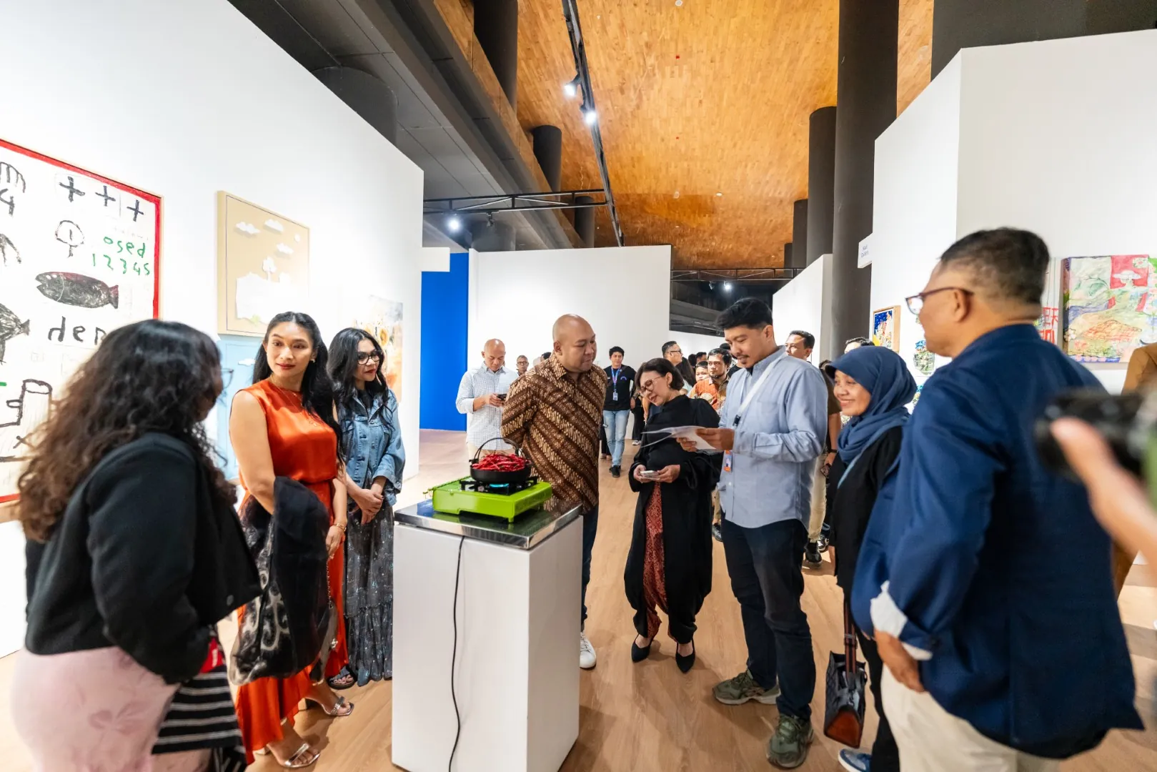 Pengunjung dan seniman berkumpul di ruang pameran Chapter Jogja Art Fair 2025, GIK UGM Yogyakarta, mengamati karya seni kontemporer yang ditampilkan.