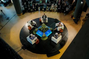 Sudut pandang atas menunjukkan forum panel Bulaksumur Roundtable 2025, dengan para pembicara duduk melingkar membahas kebijakan mengatasi krisis iklim di hadapan audiens.