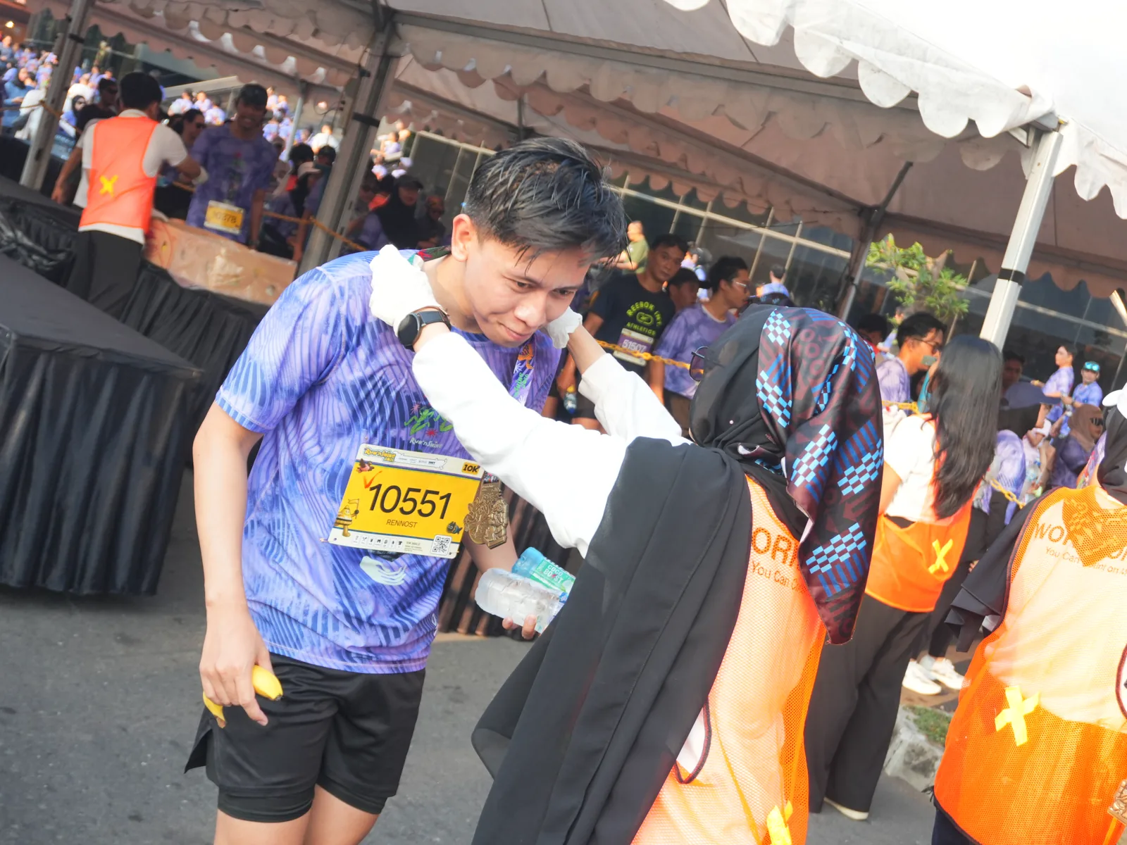 Peserta kategori 10K Run'nShine 2026 menerima medali finisher di area finish GIK UGM