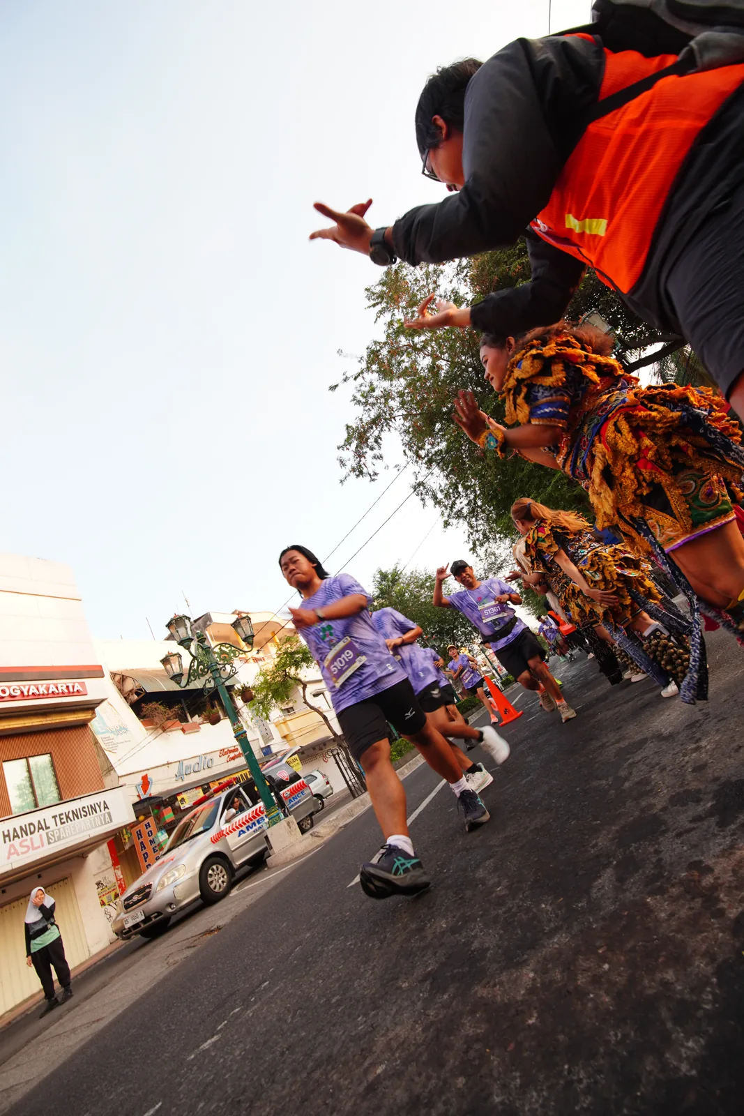 Pelari Run'nShine 2026 melintasi jalan kampung Yogyakarta diiringi penari tradisional