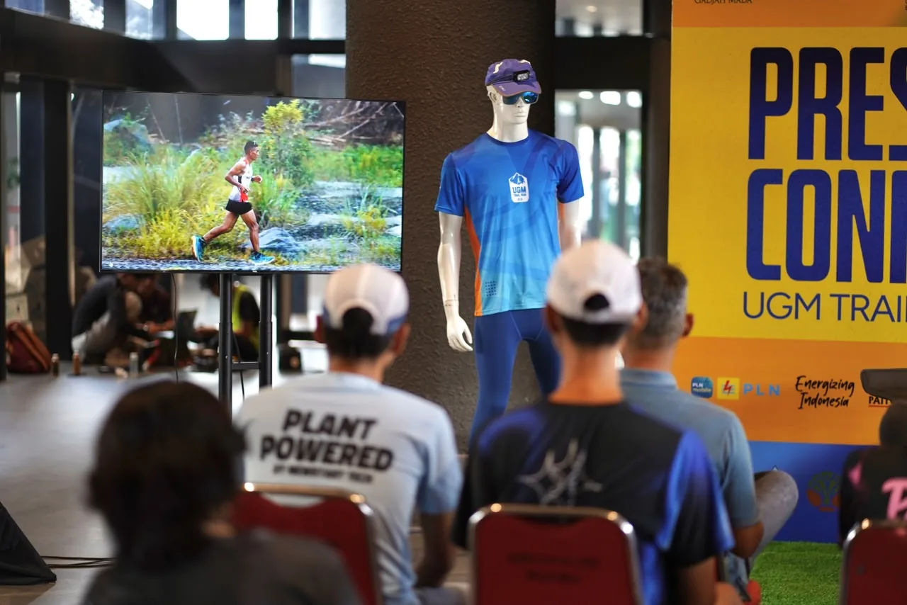 Hadirin menyimak paparan konferensi pers UGM Trail Run 2026 dengan manekin jersey dan layar foto pelari