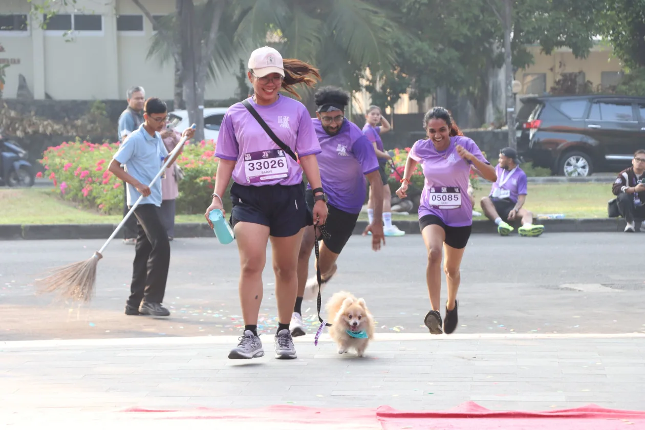 Peserta UGM Vet Fun Run 2026 melintasi garis finis bersama anjing pomeranian